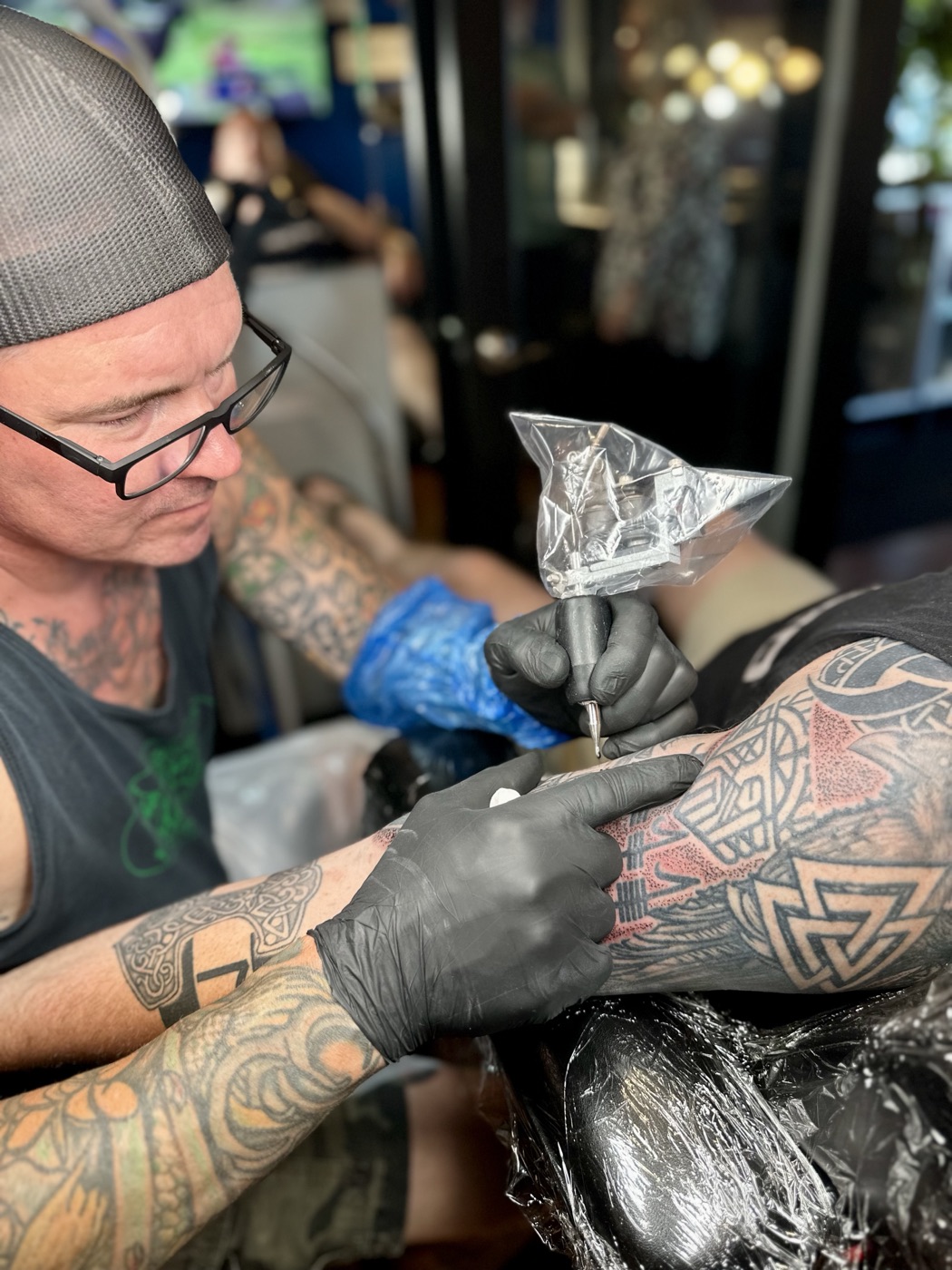 Cameron D Straub tattooing a client at Viking Tattoo Studio